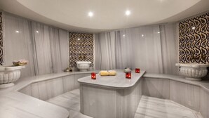 A modern bathroom with a curved design, marble walls, and a central island. - Pera Center Hotel (Istanbul)