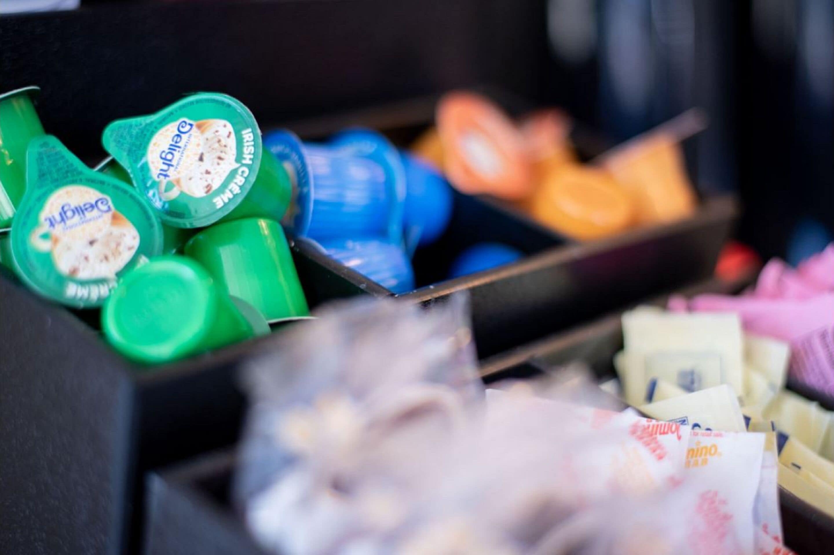 A storage area with various items including green containers labeled 'Delight Irish Cream' and blue bottles.