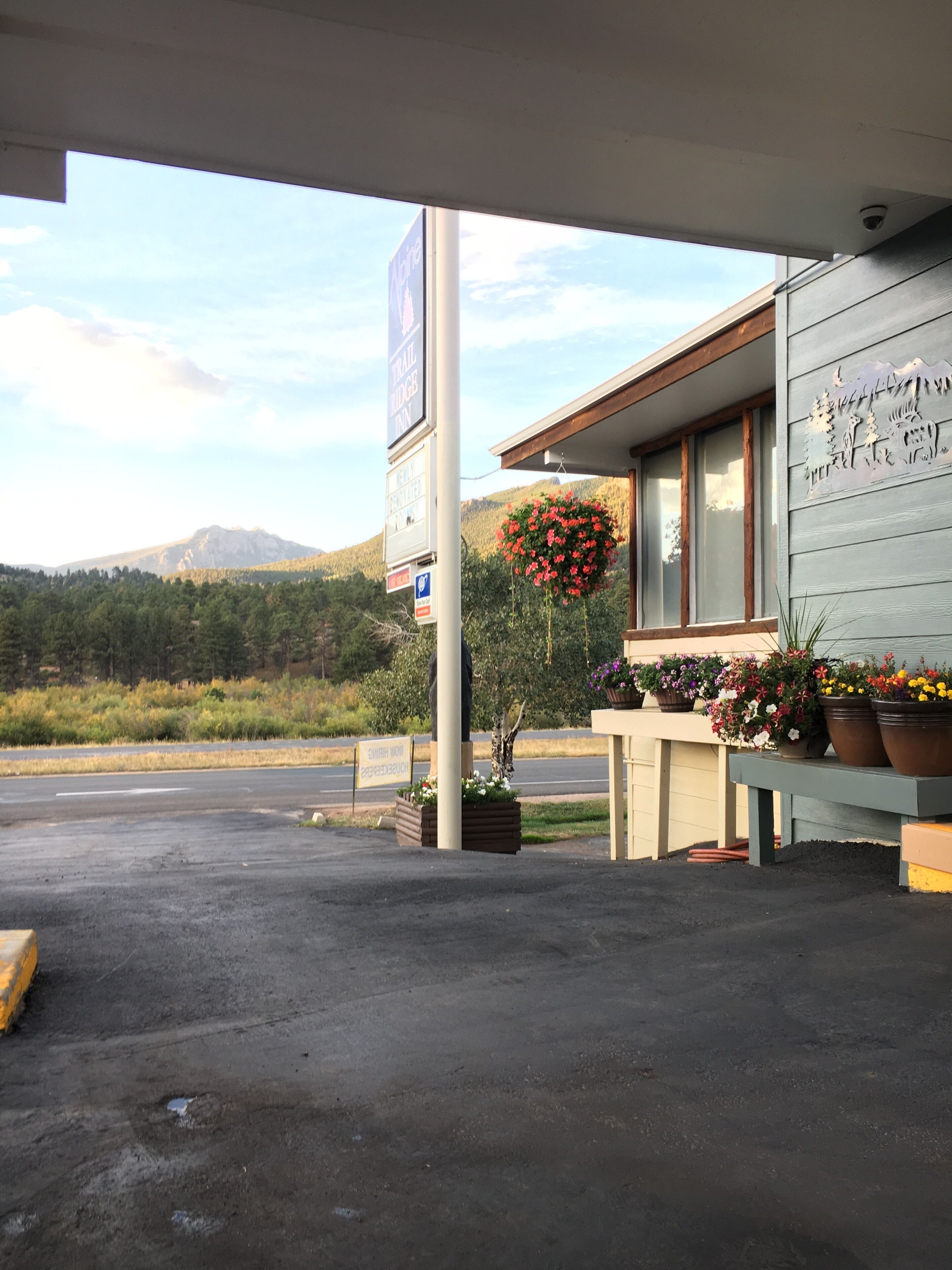 A building with a sign for 'Trail House Inn' and a mountain in the background.