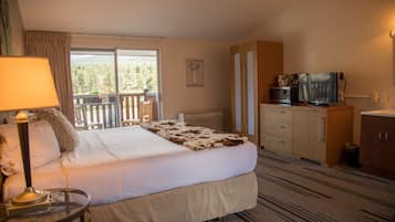 Une chambre d’hôtel équipée d’un lit, d’un bureau, d’une télévision et offrant une vue sur l’extérieur.