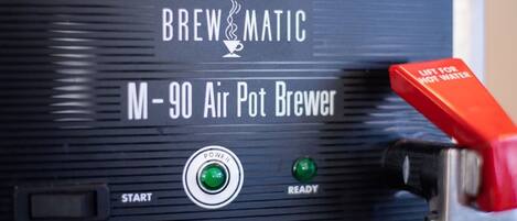 A Brewmatic M-90 Air Pot Brewer with a red lift for hot water, a power button, and a ready indicator.