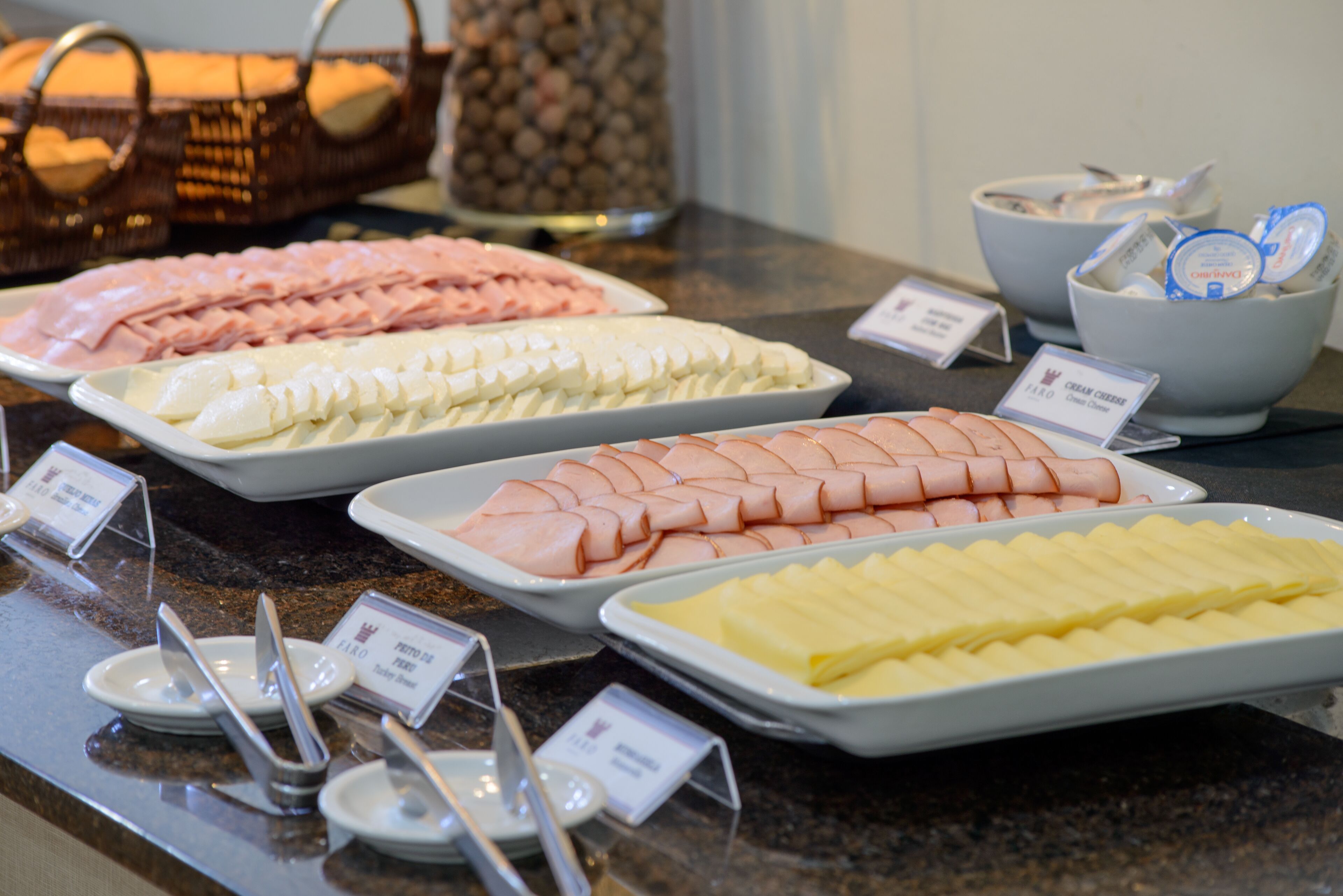 A buffet with various food items including sliced meats and cheeses.