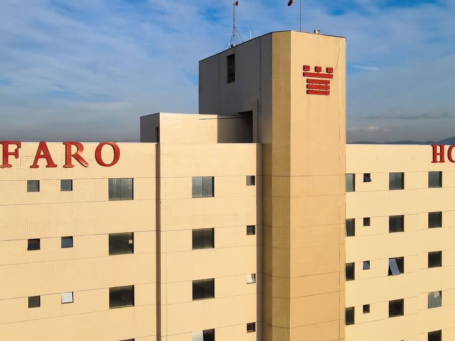 A building with "FARO HOTEL" signage, featuring a grid of windows and a central tower.
