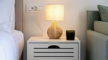 A bedside table with a lamp, a power outlet, and a nightstand drawer.