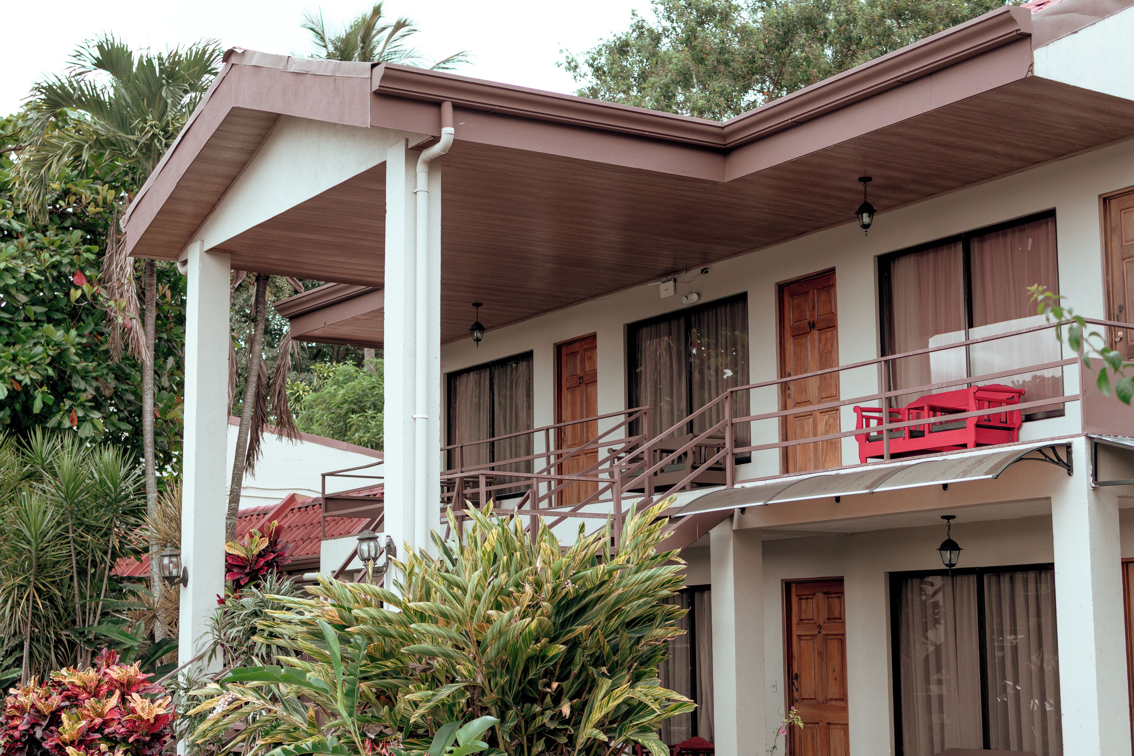 A two-story building with a balcony, wooden doors, and a staircase.