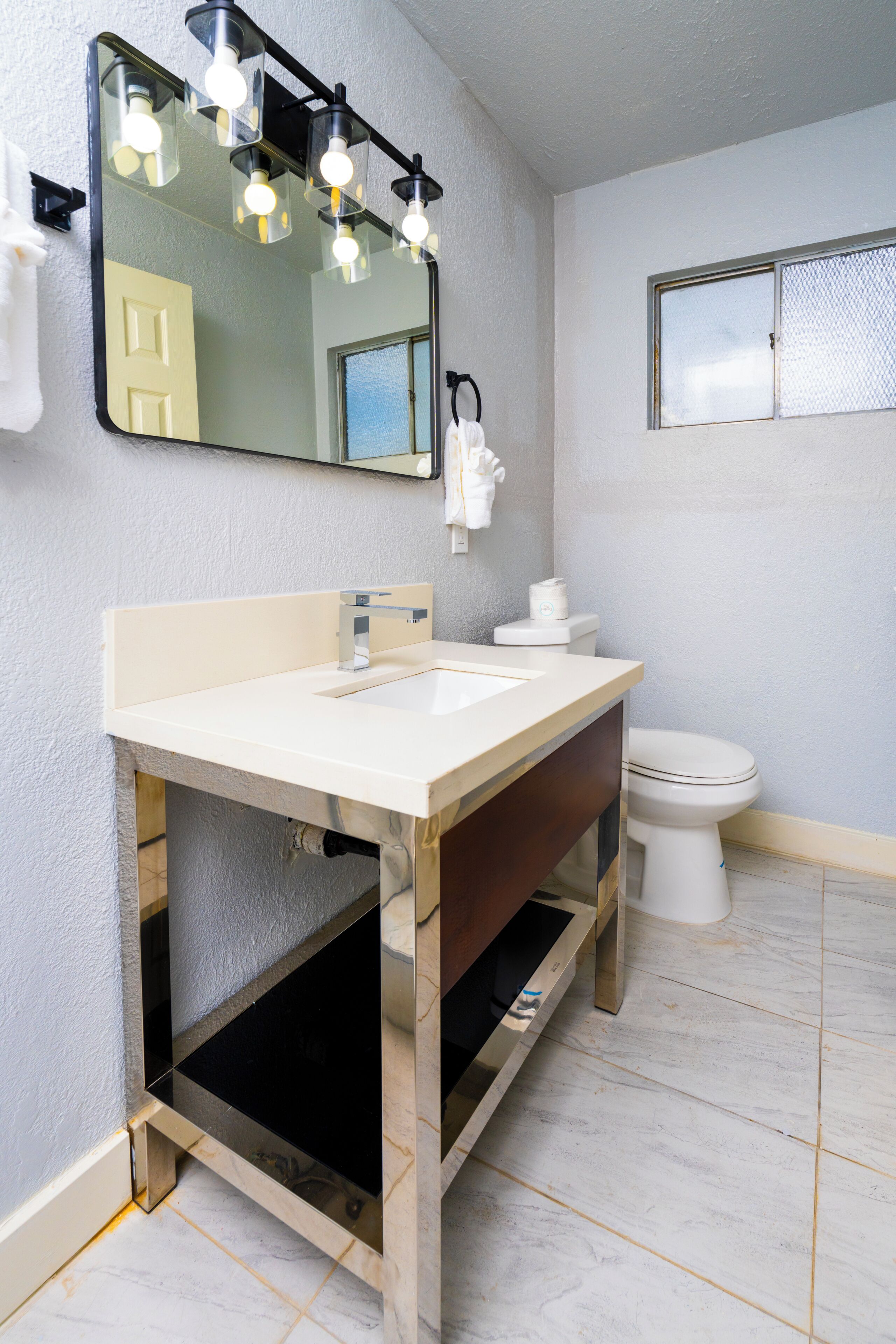 A bathroom with a sink, mirror, and toilet.