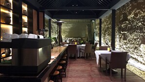 Un restaurant moderne doté d’un bar, d’un plancher en bois et d’un mur en pierre servant de décor.