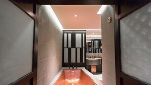 Une salle de bain moderne avec une grande baignoire, un lavabo et un miroir.