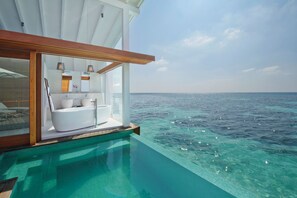 An infinity pool with a private bathroom featuring a bathtub, sink, and vanity. - Kandolhu Maldives (NORTH ARI ATOLL)