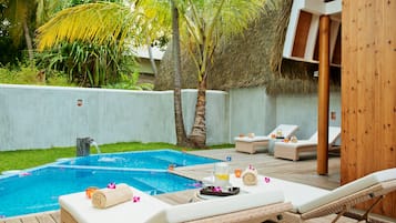 A poolside area with lounge chairs, a small pool, and a wooden deck.