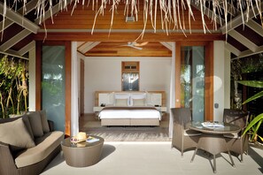 A modern bedroom with a large bed, a ceiling fan, and a glass door leading to a balcony. - Kandolhu Maldives (NORTH ARI ATOLL)