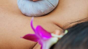 A close-up of hands applying a massage tool to a person's back.