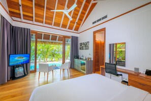 Habitación de hotel moderna con una cama grande, un escritorio, una silla, un televisor y vistas a una piscina y zonas verdes.