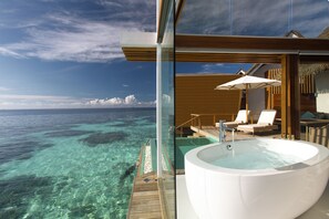A luxurious balcony with a hot tub, lounge chairs, and a view of the ocean. - Kandolhu Maldives (NORTH ARI ATOLL)