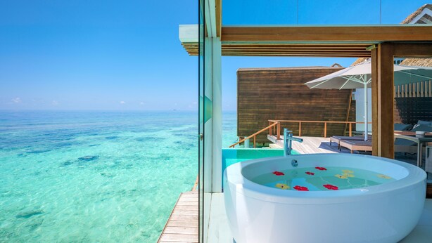 A clear view of a tropical ocean from a private balcony with a hot tub and lounge area. - Kandolhu Maldives (NORTH ARI ATOLL)