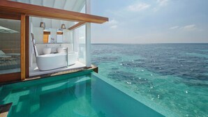 An infinity pool with a private bathroom featuring a bathtub, sink, and vanity. - Kandolhu Maldives (NORTH ARI ATOLL)