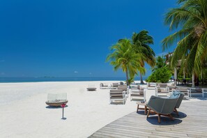 A beachside lounge with lounge chairs and a fire pit, overlooking the ocean. - Kandolhu Maldives (NORTH ARI ATOLL)