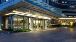 A modern hotel entrance with a glass facade, a covered walkway, and the name 'ASCOTT' prominently displayed. - Ascott Kuningan Jakarta (Jakarta)