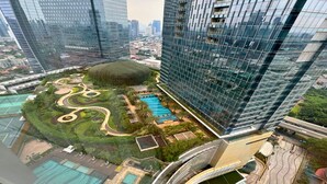 A high-rise building with a rooftop garden, swimming pool, and curved water feature. - Ascott Kuningan Jakarta (Jakarta)
