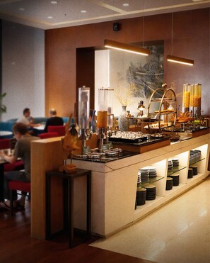 A buffet area with a central counter, various food items, and a seating area with tables and chairs. - Ascott Kuningan Jakarta (Jakarta)