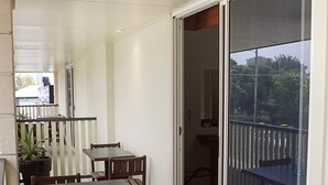 A balcony with a dining table and chairs, a potted plant, and a view of the outside. - Caboolture Gateway Motel (Caboolture)