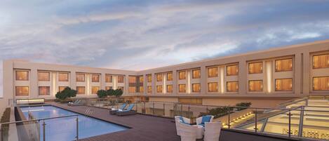 A rooftop pool area with lounge chairs and a glass balustrade.
