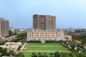 Un bâtiment moderne à étages, entouré de pelouses et d’arbres bien entretenus.