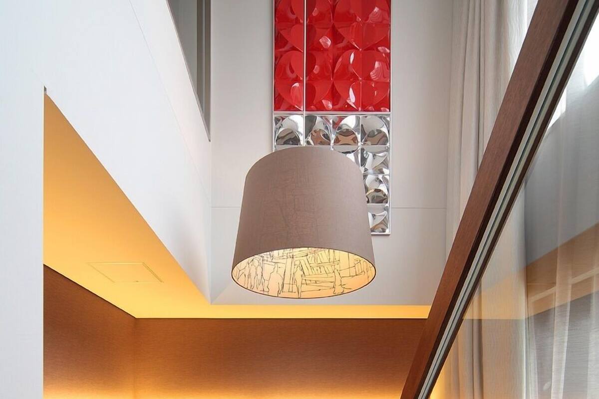 Un salon moderne avec un canapé, une table basse en bois, un téléviseur et un luminaire au plafond original.