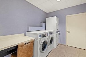 A laundry room with a washing machine, dryer, and a cabinet.