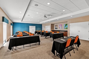 A conference room with tables and chairs, a whiteboard, and a projector on the ceiling. - Hampton Inn Omaha/West Dodge Road (Old Mill) (Omaha)