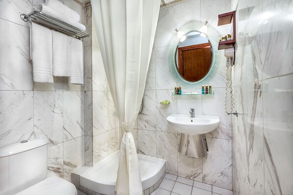 Un baño con inodoro, lavamanos y bañera.