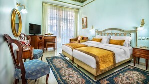 A spacious bedroom with a large bed, a desk, a chair, and a television. - Imperial Palace Classical Hotel Thessaloniki (Thessaloniki)
