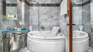A modern bathroom with a glass sink, two separate tubs, and a shower.