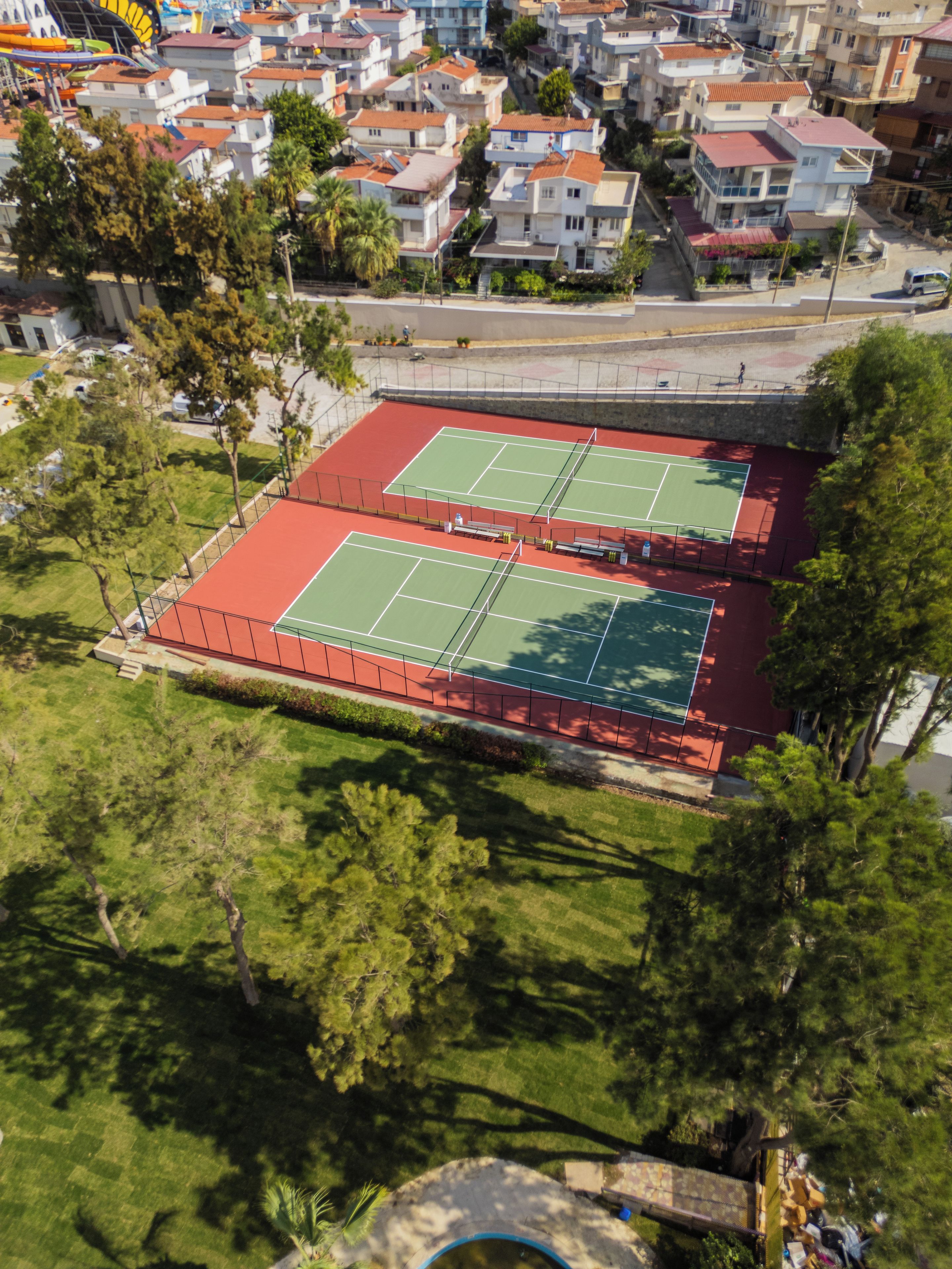 A tennis court surrounded by residential buildings.