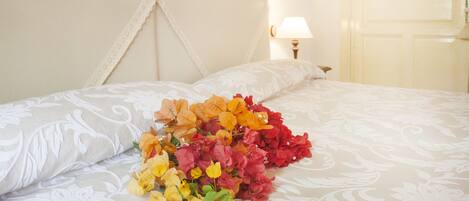 A neatly made bed with a floral arrangement on the bedspread.