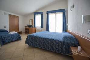 A hotel room with two beds, a desk, and a chair. - Hotel Isola Rossa (Bosa)