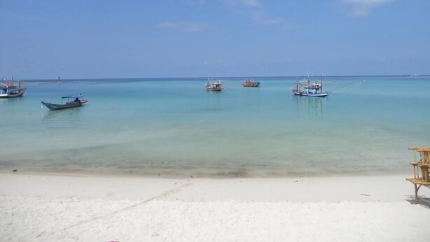 A beach with several boats anchored in calm waters. - Haad Yao Sunset Bungalow (Ko Pha-ngan)