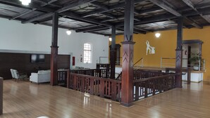 A spacious indoor area with wooden flooring, a high ceiling, and a central wooden partition. - Hara Palace Hotel (Curitiba)