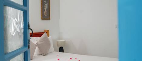 A hotel room with a bed, a nightstand, a lamp, and a painting on the wall.