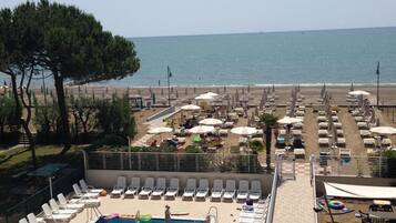 Een buitenzwembad, ligstoelen bij het zwembad