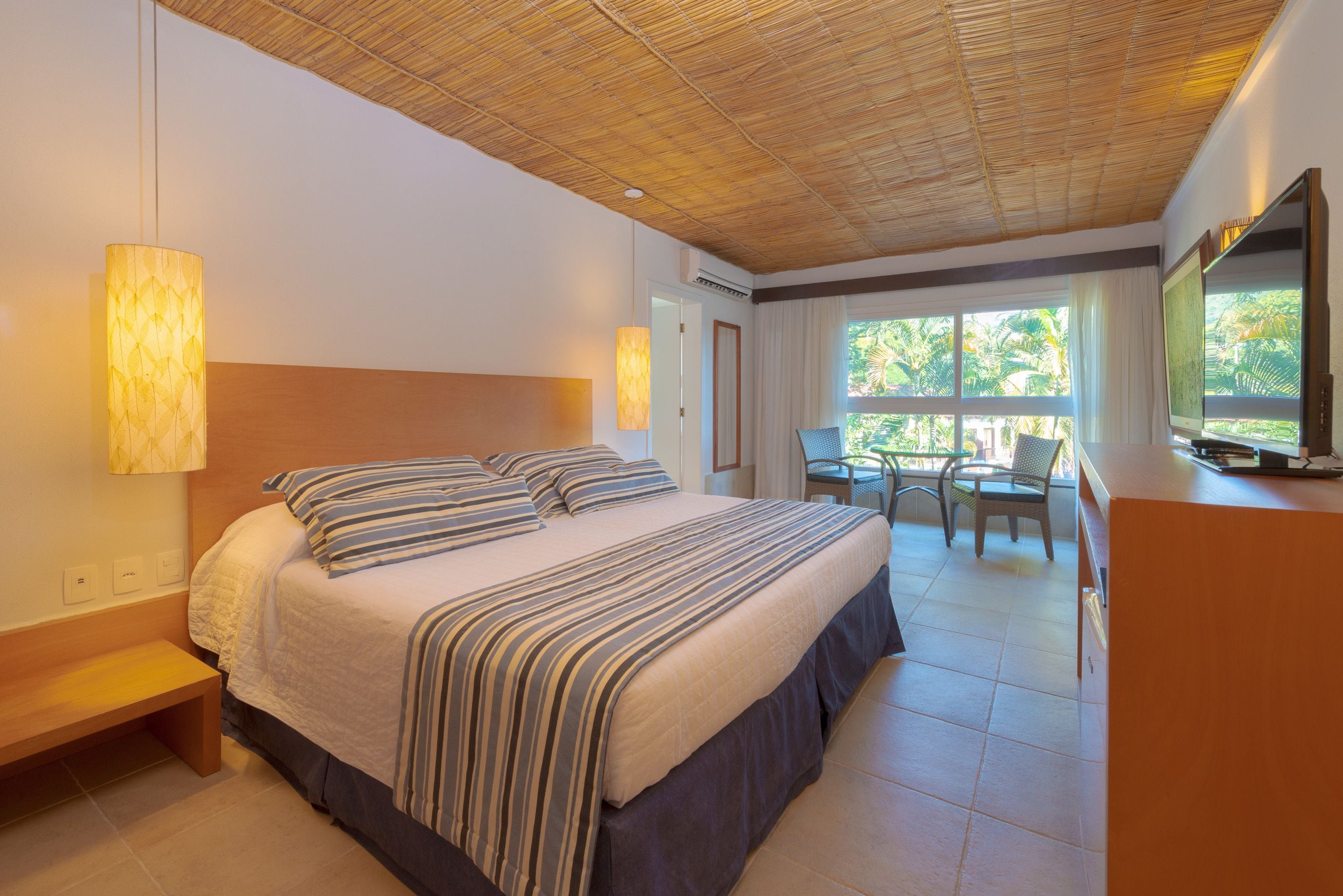 A hotel room with a large bed, a desk, and a television.