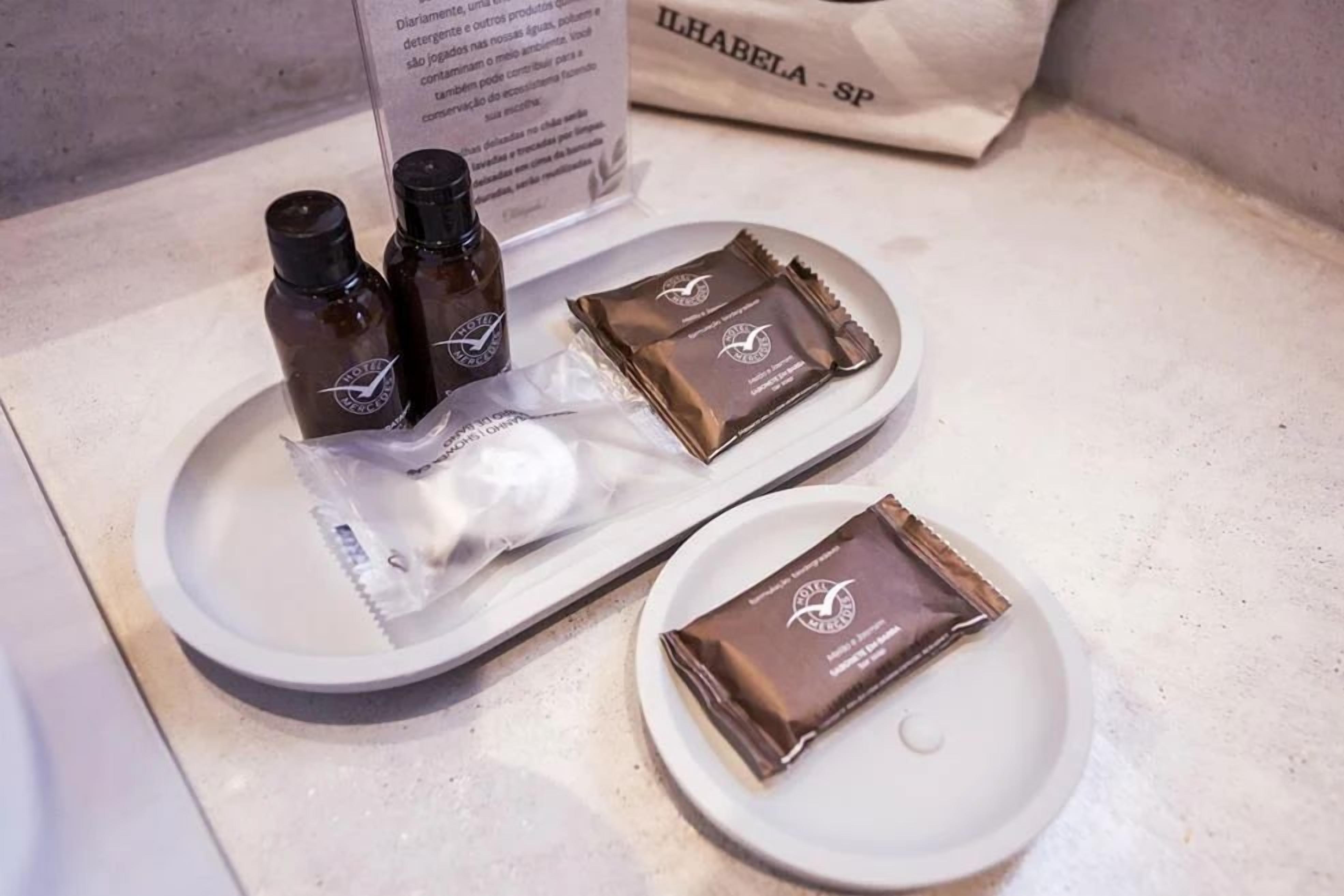 Uma bandeja com duas garrafas pequenas e duas barras de chocolate sobre um prato branco.