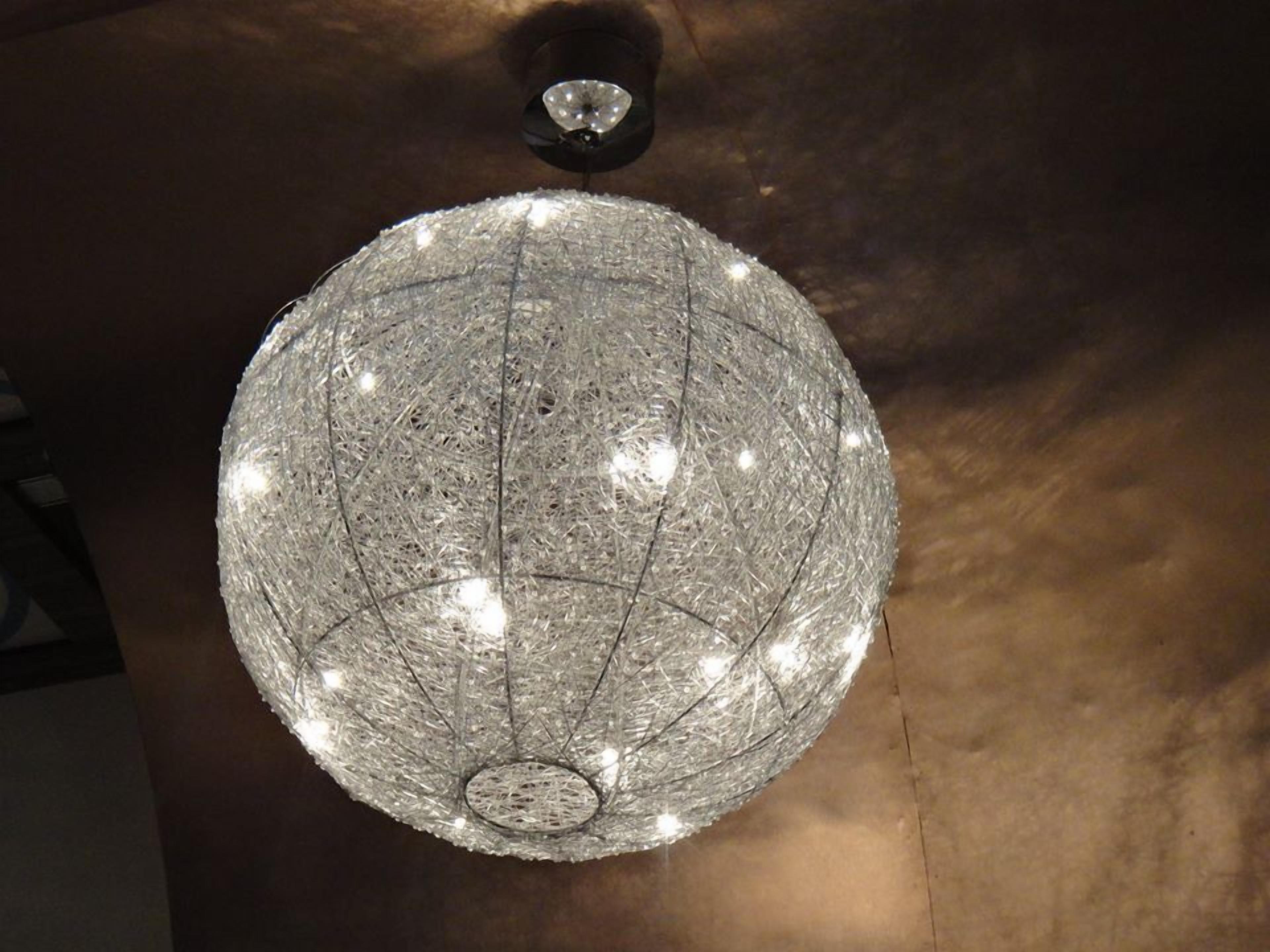 A spherical chandelier with multiple light bulbs, suspended from the ceiling.