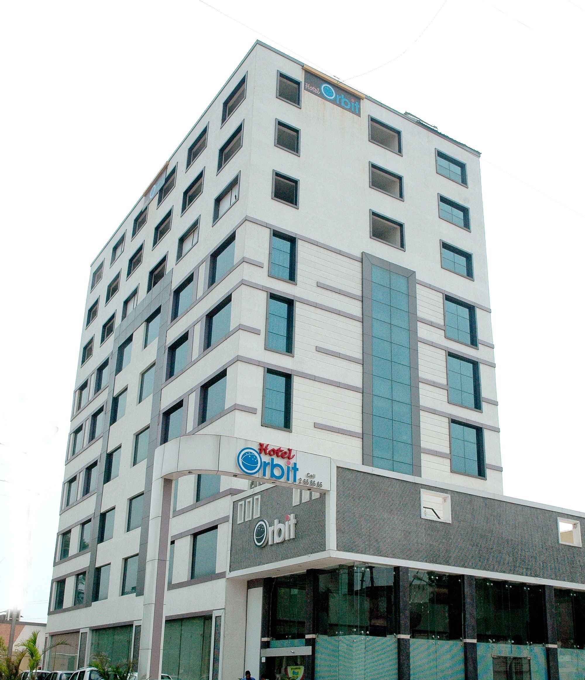 A multi-story hotel building with a modern design, featuring a prominent 'Hotel Orbit' sign on the facade.