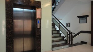 Ein Aufzug mit einer Marmorwand, einem Empfangsschild und einer Treppe zum 'Crystal Banquet' Bereich.