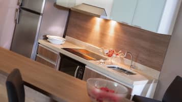 A modern kitchen with a wooden countertop, stainless steel appliances, and a sink.