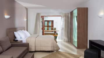 Una habitación de hotel moderna con una cama, un sofá, un televisor y un balcón con baranda de madera.