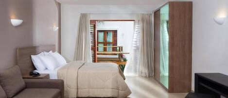 Una habitación de hotel moderna con una cama, un sofá, un televisor y un balcón con baranda de madera.