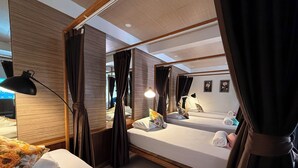 Une chambre d’hôtel avec deux lits, un grand miroir et une table de chevet avec des lampes.