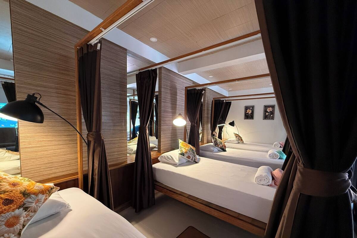 Een hotelkamer met twee bedden, een grote spiegel en een nachtkastje met lampen.